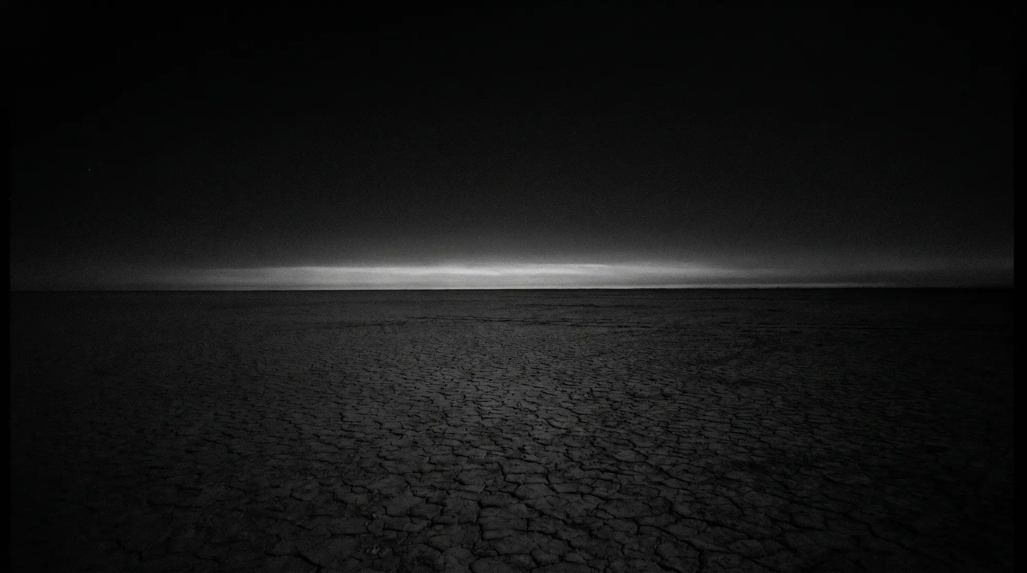 The Black Rock Desert playa, empty to the horizon under a pale sky
