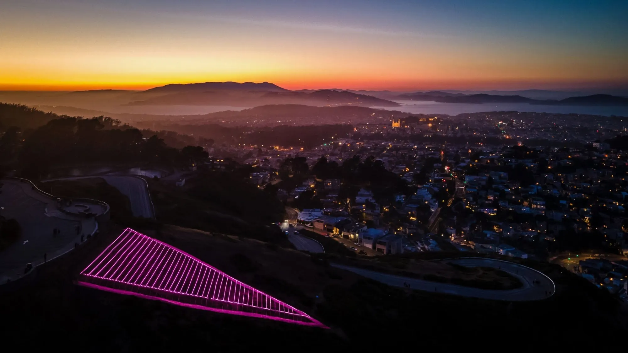 The illuminated Pink Triangle installation on Twin Peaks over San Francisco at night